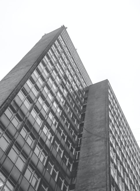 A vertical greyscale low angle shot of a residential building at daytime